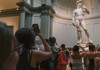 A woman taking a photo of the Statue of David while on tour with The Tour Guy.