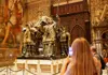 Visitors viewing the tomb of Christopher Columbus inside Seville Cathedral, with large sculpted figures holding the casket.