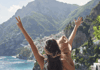 A group of tourists taking selfies in front of the colorful cliffs of Positano. 