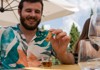 A tourist dipping a biscotti into a glass of wine while on tour with The Tour Guy.