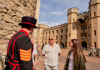 A man taking a picture of a woman while inside the London Tower.