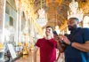 A tour group taking pictures of the grand rooms in the Versailles' Place.