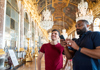 A tour group taking pictures of the grand rooms in the Versailles' Place.