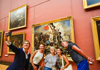 A woman next to the Winged Victory in the Louvre Museum with a guide from The Tour Guy.