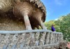 A picture of a woman standing on the Colonnaded Pathway inside of Park Guell in Barcelona. 