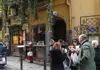 Food tour group sampling local snacks outside a traditional Naples pizzeria in the historic center.