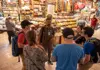 Guided food tour group gathered inside a covered market, listening as a guide explains local ingredients and specialties