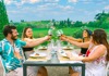 A group of tourists having their picture taken while on a vineyard in Tuscany.