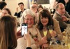 A picture of  2 tourists enjoying limoncello and taking a selfie with their tour guide in Italy. 