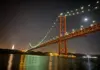 25 de Abril Bridge illuminated with city lights at night