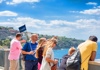 A group of people and a guide standing on a railing overlooking the Gulf of Naples