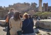 A group of tourists walking through the Roman Forum.