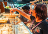 Woman picking a cheese to taste during a Paris food tour