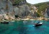 Boats in the water with a cliff and a beach