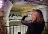 Woman taking picture of secret room at the catacombs in Paris