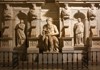 A row of classical statues carved in marble, depicting historical and religious figures with intricate detailing.