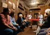 a group of tourist listening to a guide explaining about Domitillas Catacombs in Rome