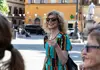 Guest holding a glass of prosecco while standing in a sunny Italian piazza