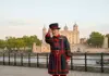 An image of two tourists standing with a Beefeater while on tour with The Tour Guy.