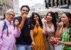 Group of people tasting fresh fruit at an outdoor market in Vienna.
