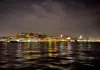 Alfama skyline illuminated at night from a river cruise