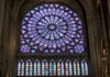 Picture of rose stained glass window inside of Notre-Dame in Paris.