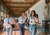 A small tour group walks through an elegant corridor lined with statues, enjoying an exclusive museum experience.