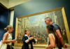A woman on tour looking at the Winged Victory statue in the Louvre Museum with her guide from The Tour Guy.