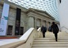 A picture of tourists walking up the stairs inside of the British Museum in London. 