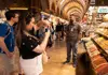 Visitors photographing colorful spice displays in a historic bazaar lined with arched ceilings and bustling stalls