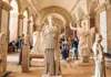 Visitors exploring a gallery of classical sculptures inside the Louvre Museum