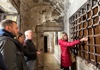 A group of tourists looking at a prison cell in the Doge's Palace dungeons and listening to a guide from The Tour Guy.