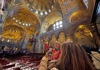 A woman taking a picture of the golden ceiling inside St. Mark's Basilica while listening to a guide from The Tour Guy.