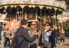 Tour guide and visitors exploring Montmartre near a traditional Parisian carousel