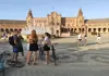 Bike tour group gathered with their guide in front of Plaza de España in Seville during a scheduled stop.