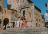 A group of tourists having their photo taken outside of Piazza della Cisterna in San Gimignano while on tour with The Tour Guy.