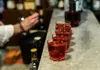 Glasses of red Italian aperitivo lined up on a marble bar counter