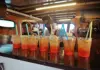 Bartender preparing mixed drinks at the onboard bar during a boat tour.