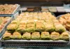 Tray of pistachio baklava displayed behind glass in a Turkish pastry shop