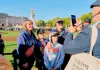 a guide taking a picture of a group of tourists in front of the Buckingham Palace