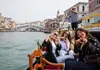 A family sitting on a gondola in Venice.