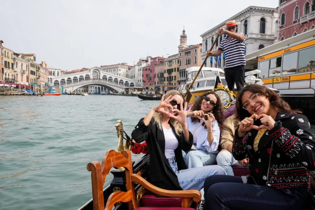 A family sitting on a gondola in Venice.
