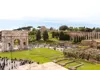 A group of tourists walking through the Roman Forum.