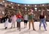 A group of tourists poses inside the Colosseum, smiling with the amphitheater’s ruins in the background.