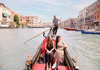 A picture of the Bridge of Sighs with a gondola passing under.