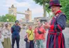 Two tourists taking a picture with a Tower of London Beefeater while on tour with The Tour Guy.