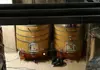 Large wooden wine fermentation barrels inside a winery production room.