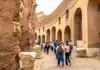 A tourist walking through the Colosseum along with a guide from The Tour Guy.