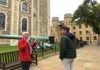 A man inside the Tower of London speaking with his guide from The Tour Guy.