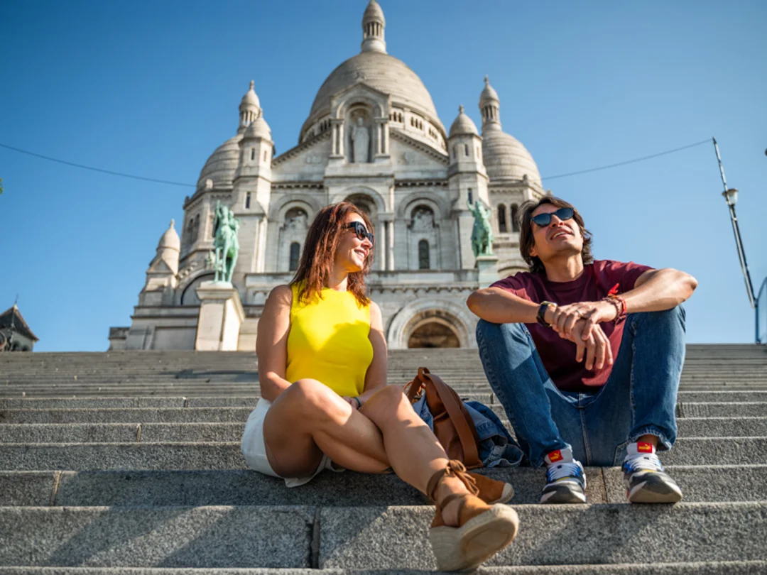 A man in front of the Louvre Pyramid with a guide from The Tour Guy.